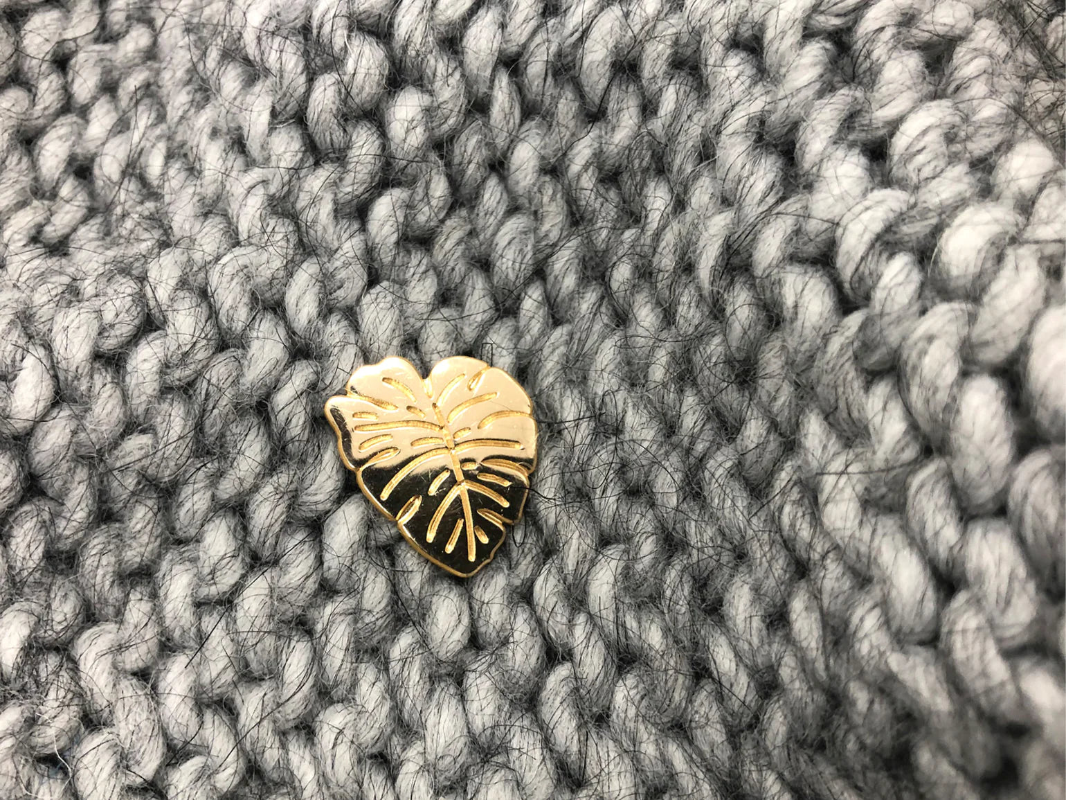 gold plated handmade plant leaf pin by Typealive, on grey knit