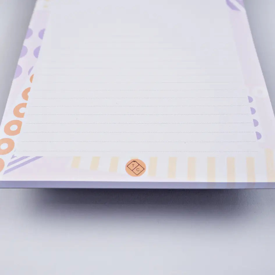 bottom of note pad ephemera by the completist, with abstract lilac and orange dots