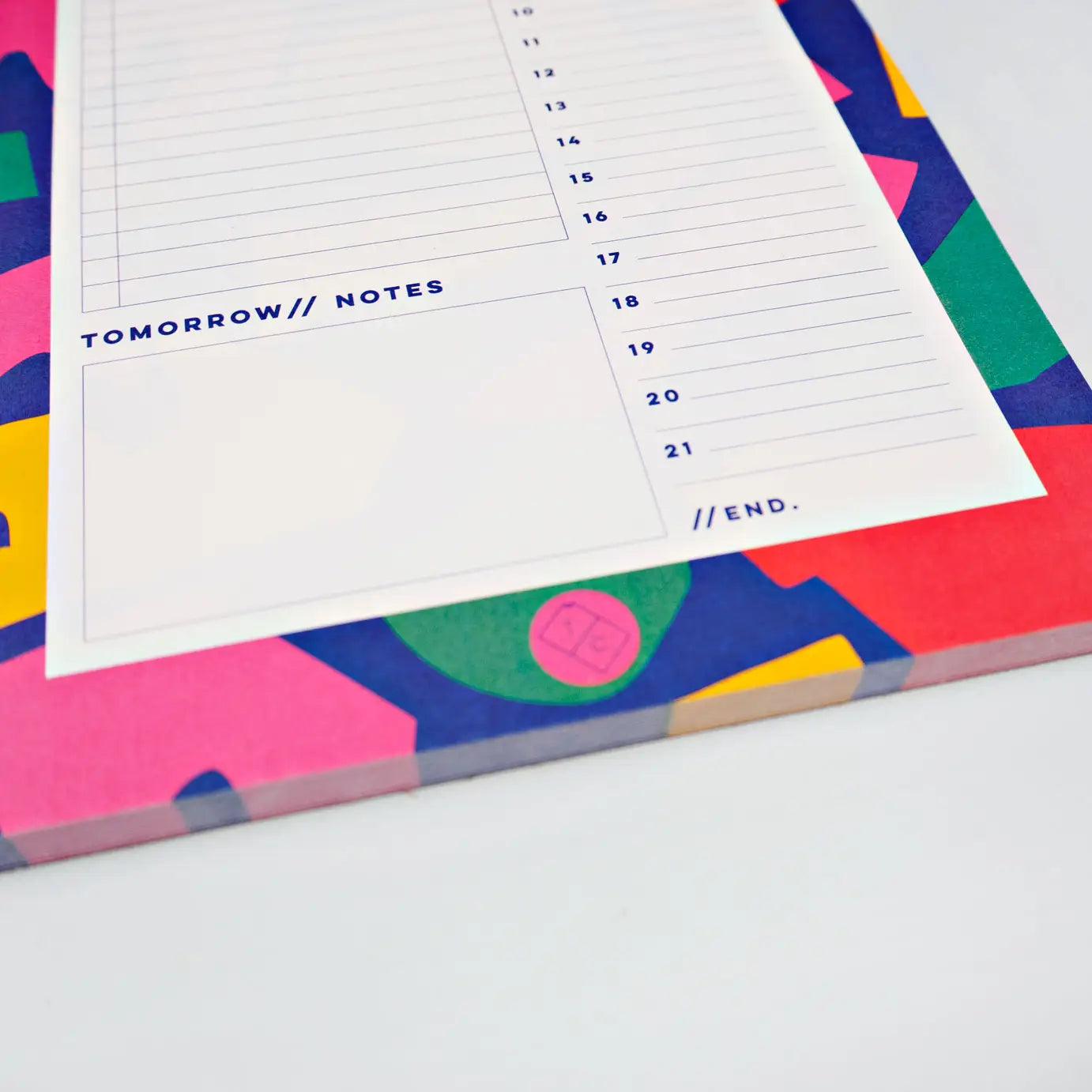 bottom of planner pad cut out shapes by the completist, with shapes in bold red, blue, green, pink and yellow