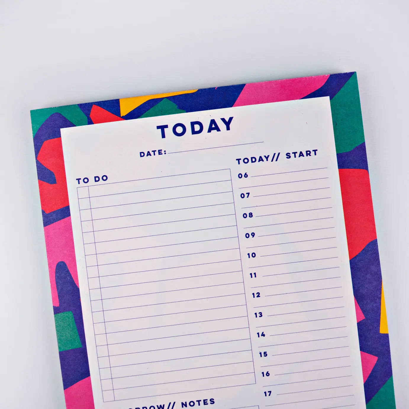 top of planner pad cut out shapes by the completist, with shapes in bold red, blue, green, pink and yellow