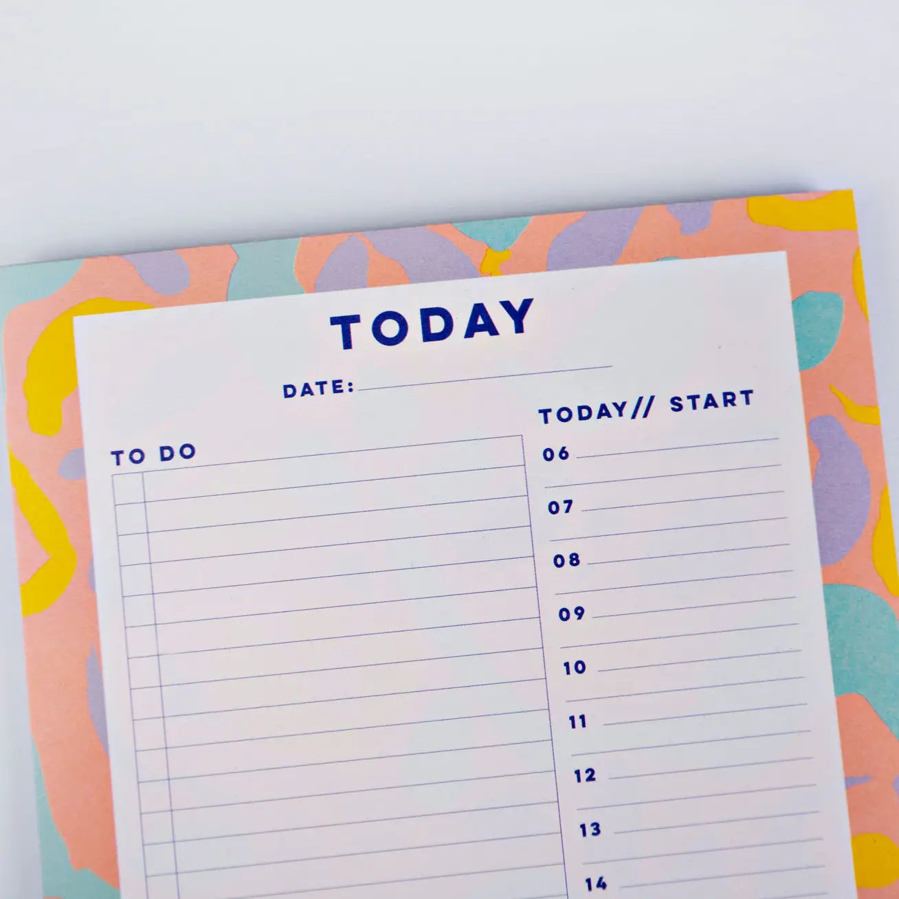 top of planner pad Inky by the completist, with swirls of yellow, orange, mint and purple