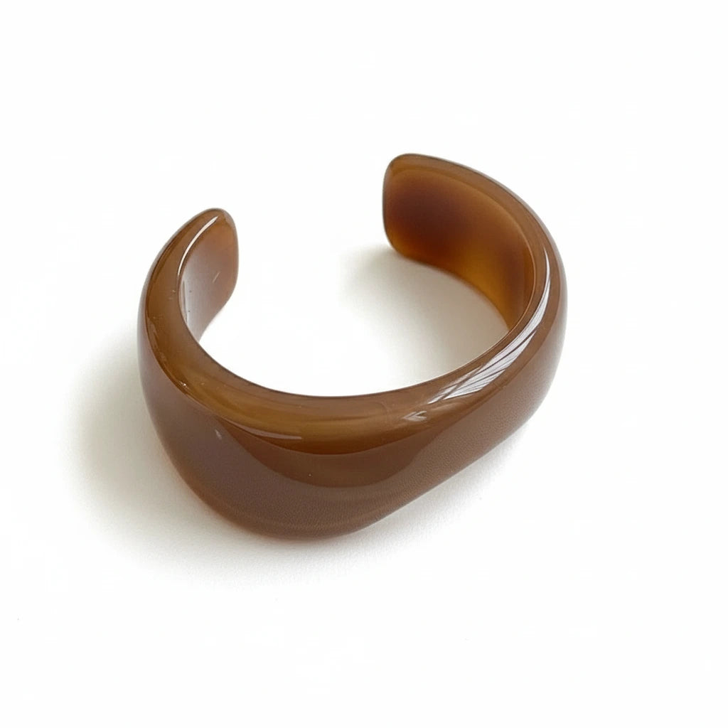 Brown resin cuff bracelet on a white surface