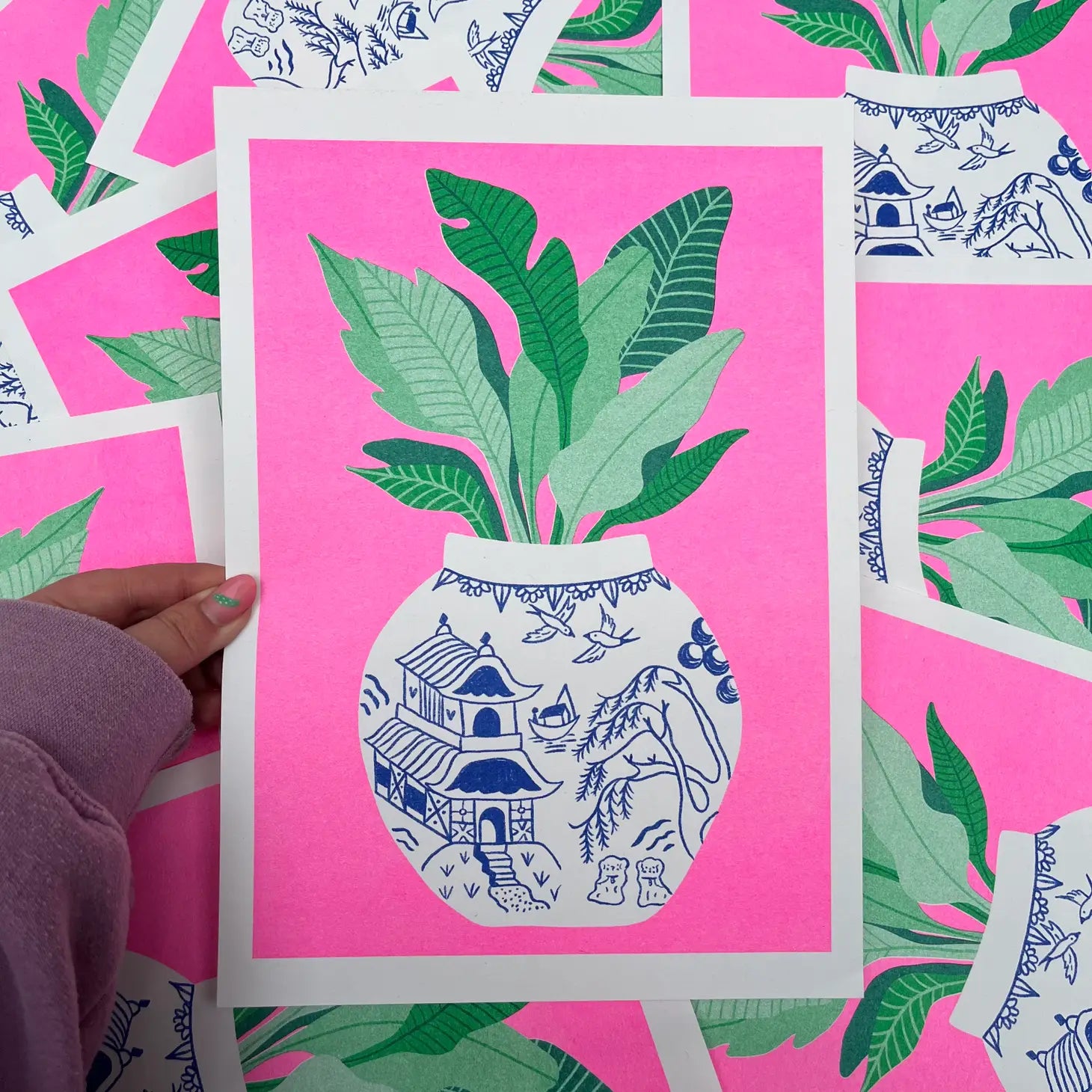 handmade print willow pattern by Amy Hastings, neon pink background with green plant in white and blue printed vase