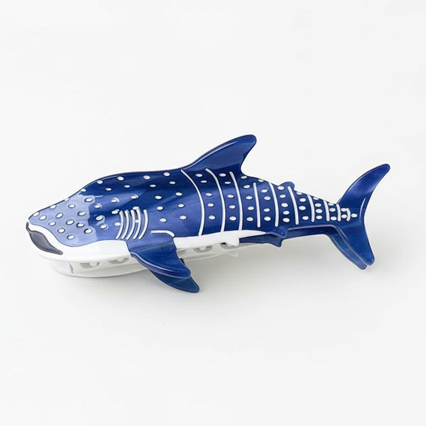 A blue and white hair clip designed to resemble a shark.